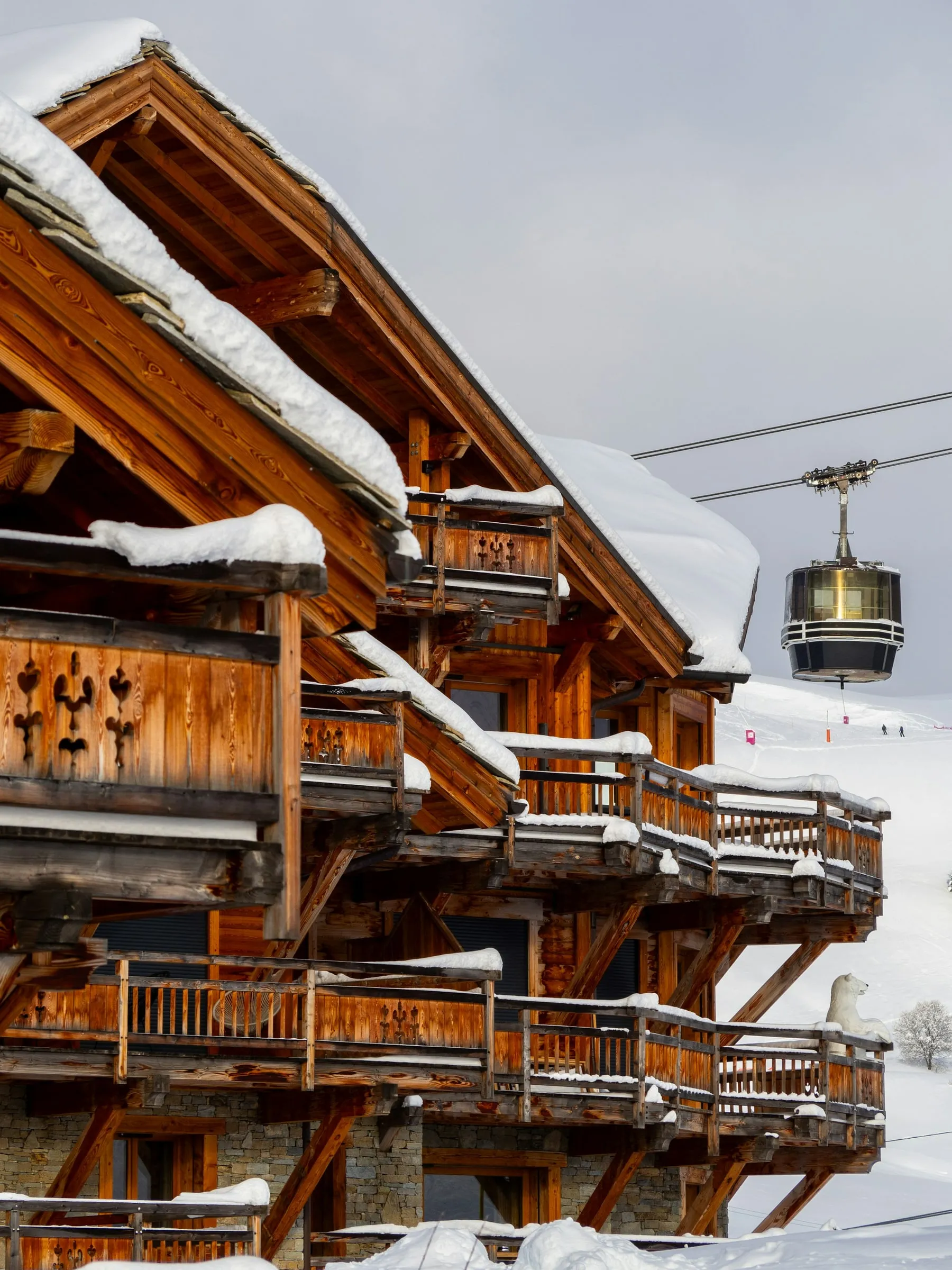 Wooden chalet under snow and a cable car