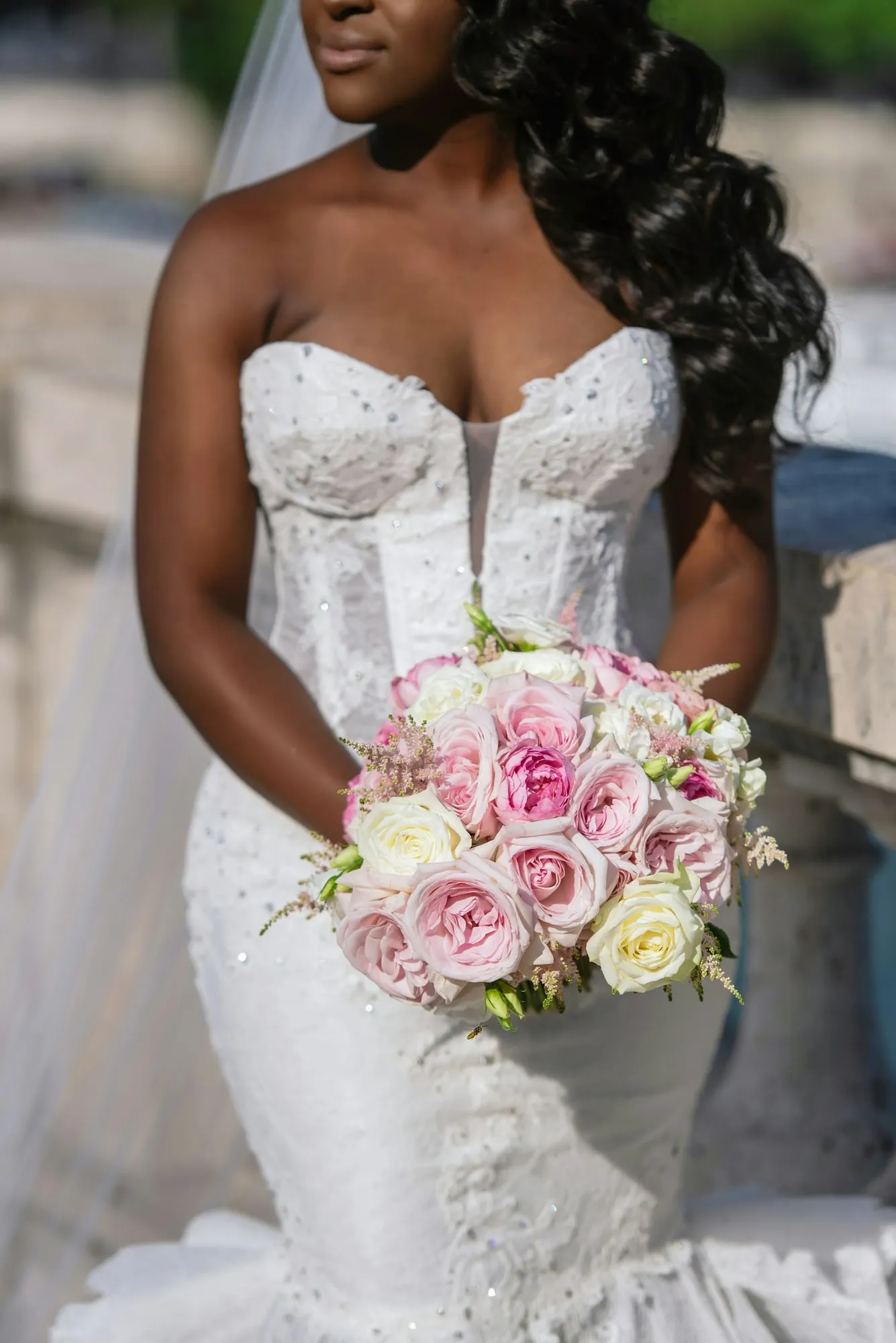 The bride in an embroidered bodice holding a bouquet of roses