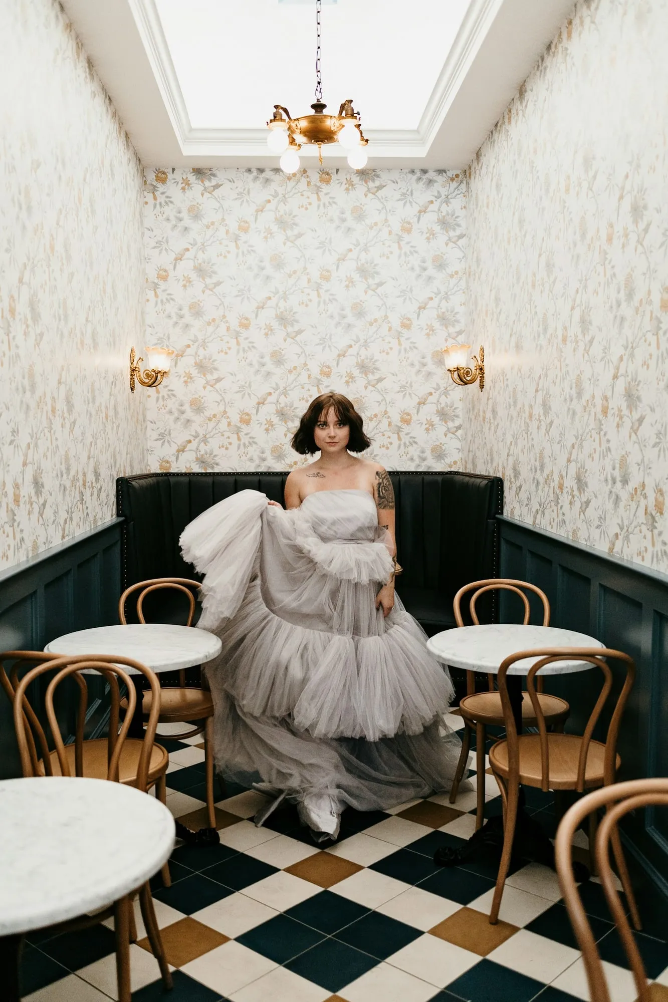 The bride seated in a Parisian café with black and white tiles