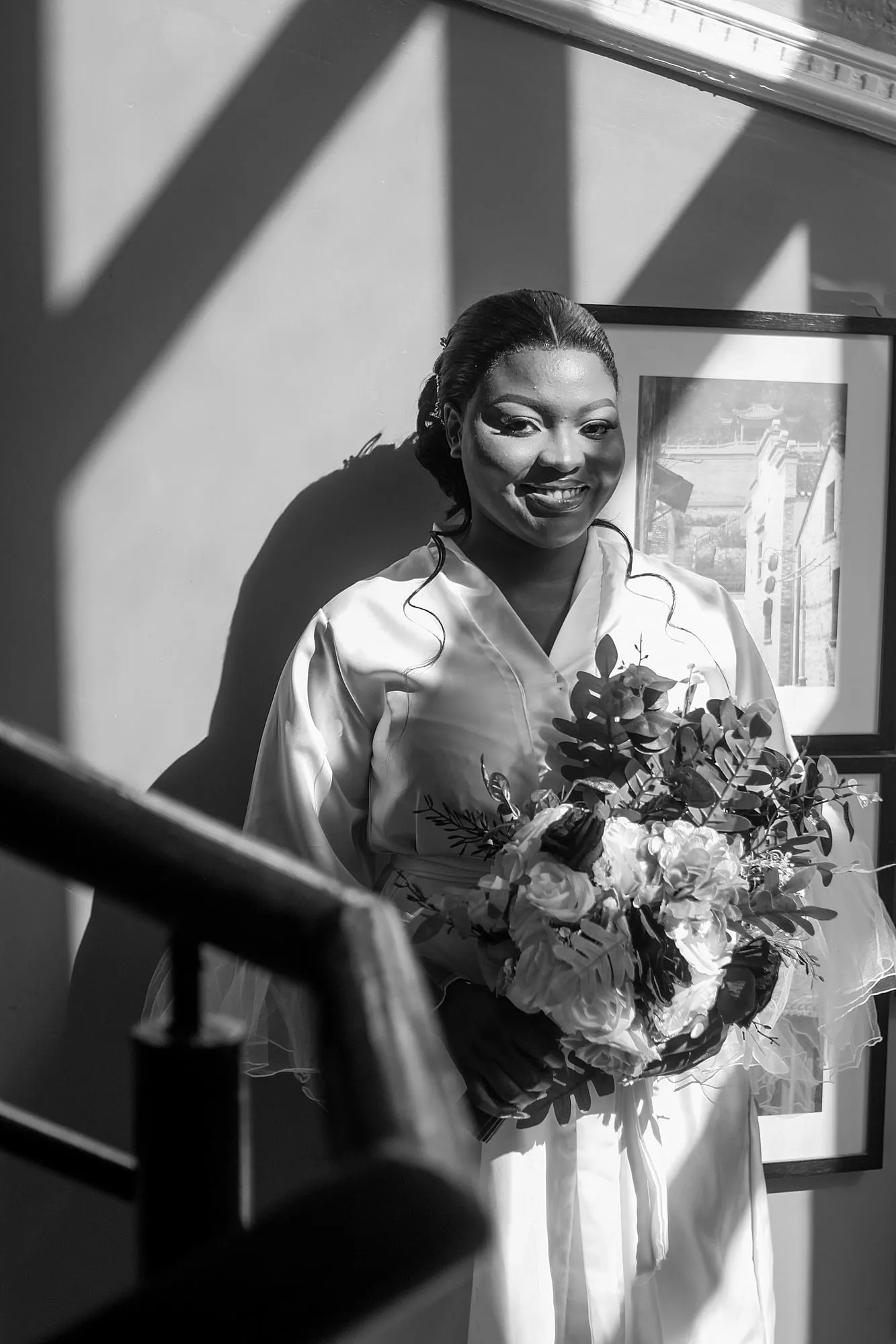 The bride smiling with her bouquet, black and white