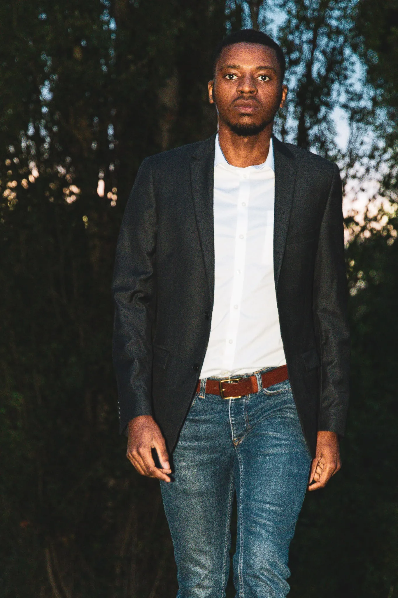 Man in a blazer walking towards the camera at night
