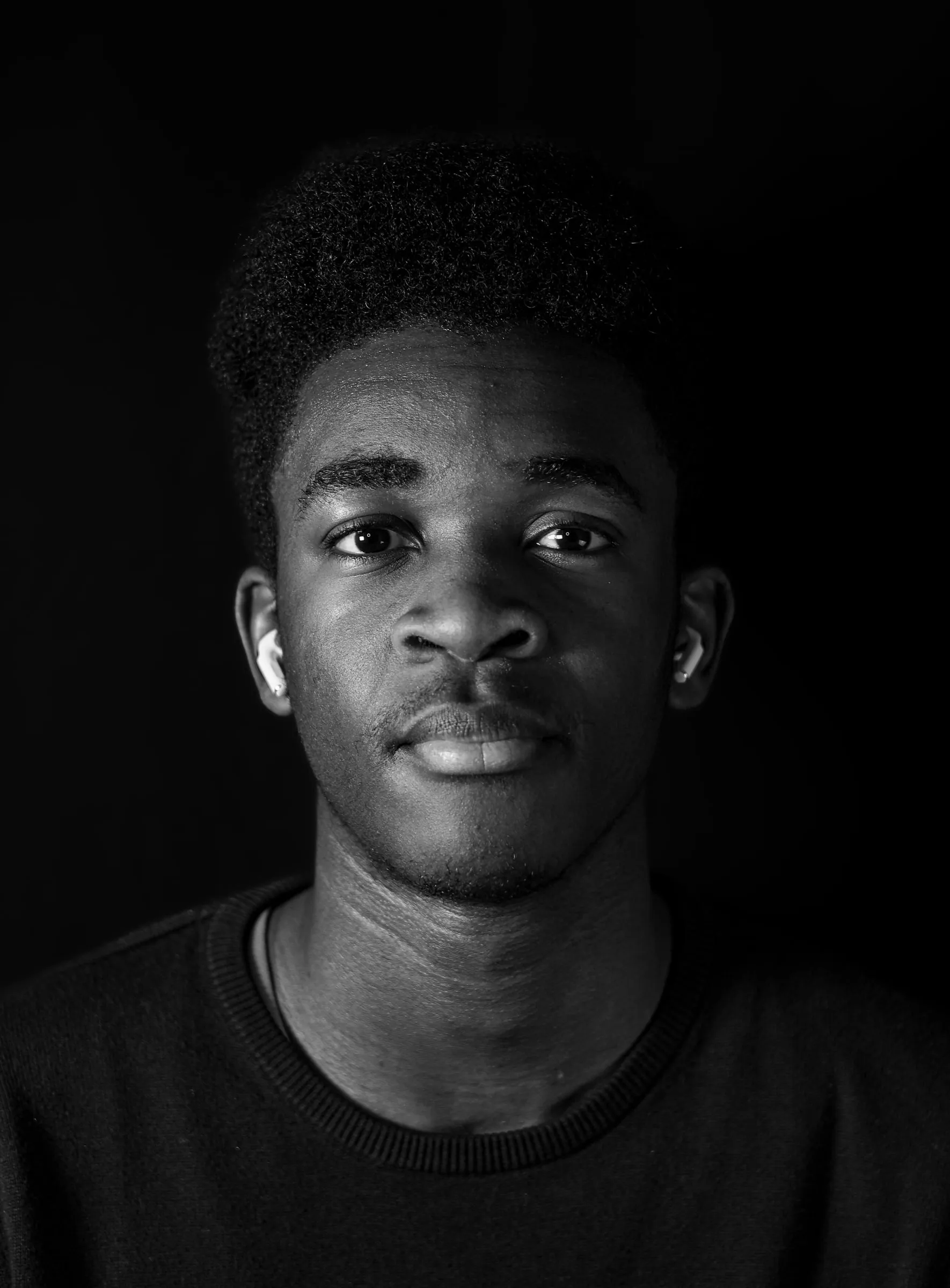 Black and white portrait of a young man, a single light on a black background