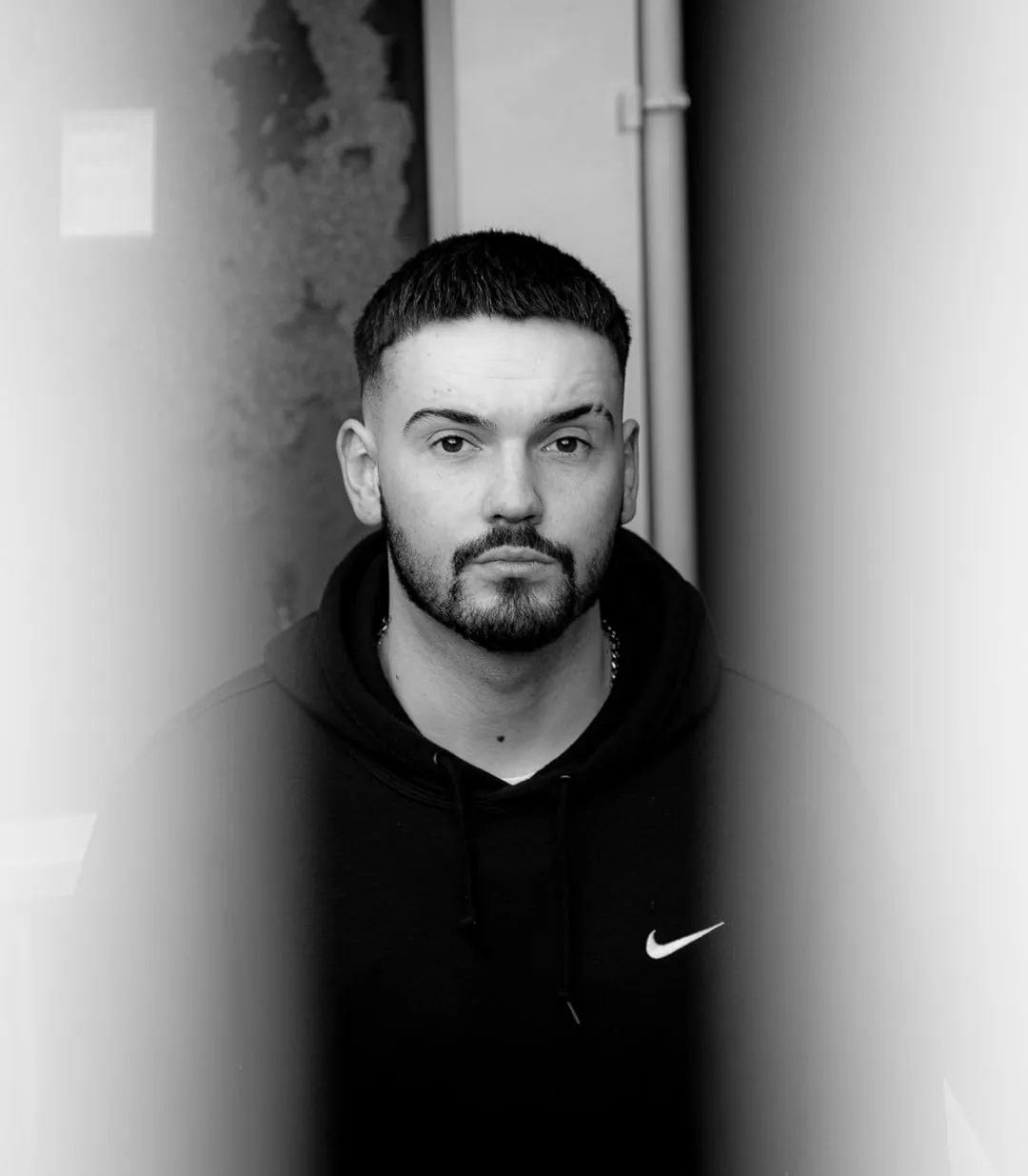 Black and white portrait, light grazing along a wall